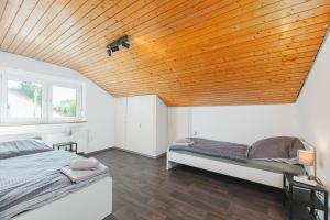 a bedroom with two beds and a wooden ceiling at MONTEURWOHNUNG Göppingen GP04 RAUMSCHMIDE Apartments in Göppingen