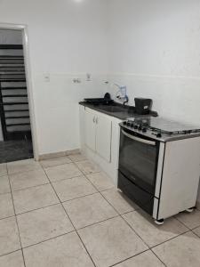 eine Küche mit Herd und Spüle in der Unterkunft Casa espaçosa em Belo Horizonte in Belo Horizonte