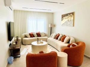 ein Wohnzimmer mit 2 Sofas und einem Tisch in der Unterkunft Spacious new 2 bedroom Apt-in amazing location B33 in Riad