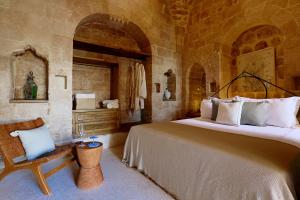 1 dormitorio con 1 cama grande y 1 silla en Aruramardin, en Mardin