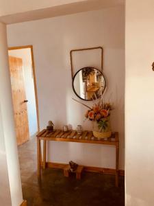 a mirror on a wall next to a wooden table at Posada - Casa Recreacional Guasimal in Bávaro