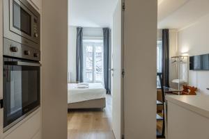 una cucina e una camera con letto e finestra di Sant'Andrea Charme Apartments a Milano