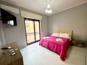 sypialnia z łóżkiem z różowym kocem w obiekcie Greta's Apartment w mieście San Giorgio a Cremano