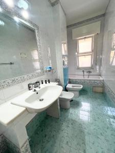bagno bianco con lavandino e servizi igienici di Greta's Apartment a San Giorgio a Cremano