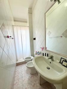 bagno con lavandino, servizi igienici e specchio di Greta's Apartment a San Giorgio a Cremano