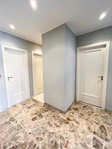una stanza vuota con due porte e un pavimento in pietra di Greta's Apartment a San Giorgio a Cremano