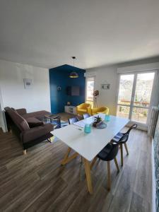 een woonkamer met een tafel en een bank bij L'escapade Familial seh'loué in Saint-Brieuc
