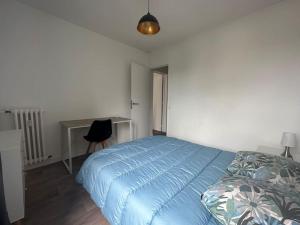 um quarto com uma cama azul e uma secretária em L'escapade Familial seh'loué em Saint-Brieuc