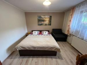 a bedroom with a large bed and a chair at POKOJE GOŚCINNE U ANIELI in Szczyrk