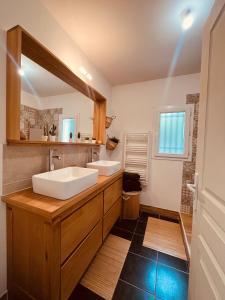 uma casa de banho com 2 lavatórios e um espelho grande em La villa Casa Vaunage em Boissières
