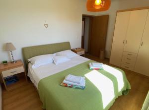 a bedroom with a bed with two towels on it at Villa Oliva in Gruda