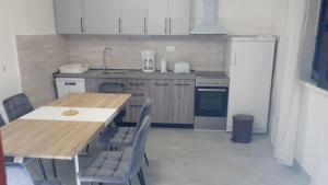 a kitchen with a wooden table and a refrigerator at MILDA+M in Skradin