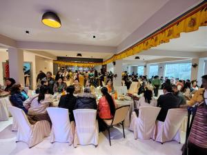 Un grupo de personas sentadas en mesas en una habitación. en Maplewood Hotel & Spa, en Gangtok