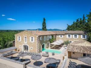 an estate with a swimming pool in front of a building at Mas Loisonville in Grillon