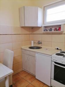 a small kitchen with a sink and a stove at Apartman Biljana in Šabac