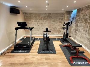 a gym with treadmills ellipticals and exercise bikes at Hotel Peyris Opera in Paris