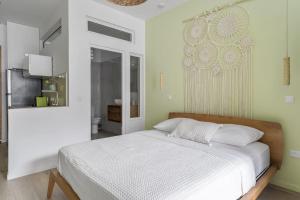 1 dormitorio con cama blanca y espejo en Jardin Bohème, en Fort-de-France