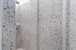 eine Dusche mit einer mit Konfetti bedeckten Wand in der Unterkunft Jardin Chic in Fort-de-France