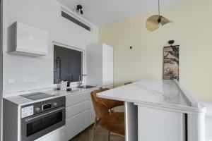 a kitchen with white cabinets and a counter top at Jardin Chic in Fort-de-France