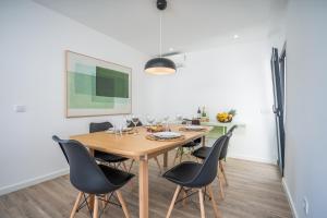 a dining room with a wooden table and chairs at Host Wise - Bright Spacious House Swimming Pool in Porches