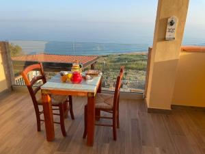 una mesa y sillas con un plato de comida en el balcón en Re Mare B&B, en Crotone