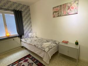a small bedroom with a bed and a window at Lägenheter Ljungaverk Apartments Ljungaverk in Ånge
