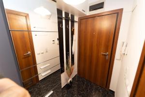 uma casa de banho com uma porta de madeira e um piso preto em Апартамент за гости Уют em Burgas