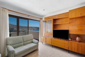 sala de estar con sofá y TV de pantalla plana en La Colina Atlantic View By Paramount Holidays, en Arona