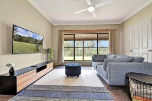 a living room with a couch and a flat screen tv at 5br Bbq Hot Tub Family Farm Stay Homestead in Lovedale