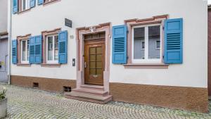une maison avec des volets bleus et une porte en bois dans l'établissement Altstadttraum, à Endingen am Kaiserstuhl