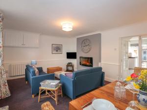 sala de estar con 2 sillas azules y sofá en The Stables, en Wisbech