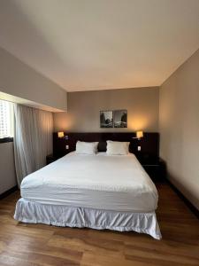 a bedroom with a large white bed with two pillows at Getaflat-1504 Berrini 4 estrelas in São Paulo