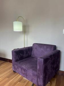 a purple couch in a room with a lamp at Getaflat-1504 Berrini 4 estrelas in São Paulo