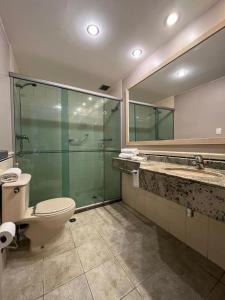 a bathroom with a toilet and a glass shower at Getaflat-1504 Berrini 4 estrelas in São Paulo