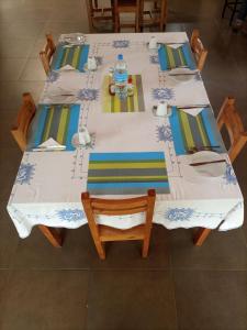 una mesa blanca con sillas y una botella de agua. en STC.SAFARI LODGE, en Oldeani