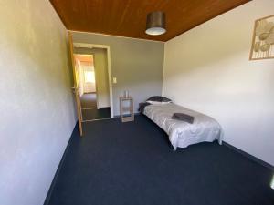 ein Schlafzimmer mit einem Bett in der Ecke eines Zimmers in der Unterkunft le Relais du Doubs in Soubey