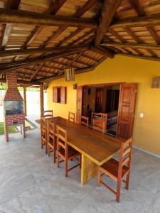 a dining room with a wooden table and chairs at Bahia Haus Don Pietro in Canavieiras