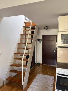 a white staircase in a room with a kitchen at Apartman Mak in Mostar