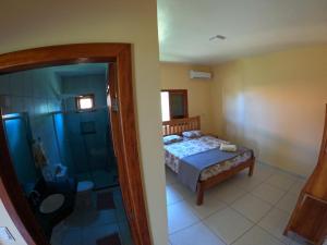 Schlafzimmer mit einem Bett und einer Glasdusche in der Unterkunft Bahia Haus Don Pietro in Canavieiras