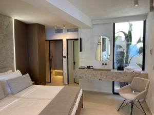 1 dormitorio con cama, lavabo y espejo en Mystique Luxury Suite en Achlia