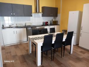 cocina con mesa blanca y sillas negras en T3 pratique, Garage gratuit, Esprit Auber, en Béziers