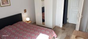 Un dormitorio con una cama con una manta roja. en T3 pratique, Garage gratuit, Esprit Auber, en Béziers 4 fotos más