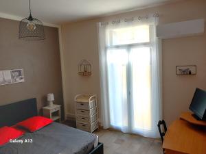 Un dormitorio con una cama y una ventana grande. en T3 pratique, Garage gratuit, Esprit Auber, en Béziers