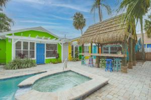a villa with a swimming pool and a house at Seaside Retreat Cottages #4 in Clearwater Beach