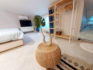 a room with a bed and a swan on a stool at Jin House Incheon Geomamstation in Incheon