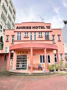 a pink hotel building with a table in front of it at Amrise Hotel 12 in Singapore