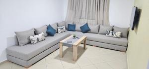 sala de estar con sofá gris y almohadas azules en La Paloma Blanca en Tetuán