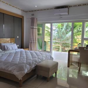 een slaapkamer met een groot bed en een groot raam bij Mpatsa Quest Hotels in Lilongwe