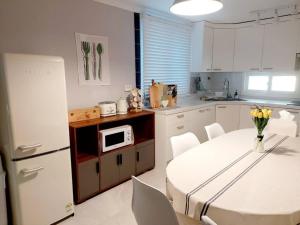a kitchen with a white table and a white refrigerator at Jin House Incheon Geomamstation in Incheon