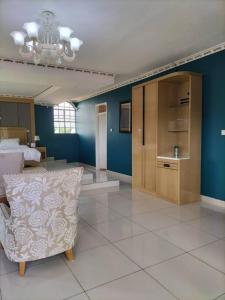 ein Schlafzimmer mit einem Bett und einem Sofa in einem Zimmer in der Unterkunft Mpatsa Quest Hotels in Lilongwe